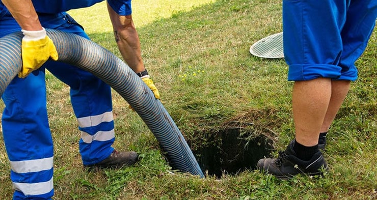 Plumbers inspecting a sewer line.